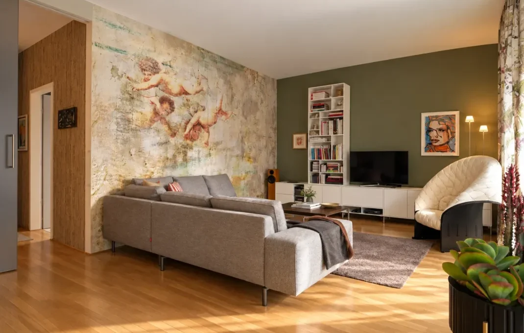Interior Coach - Innenarchitektur in Frankfurt - Wohnraum mit Loungesofa Individuell gestalteter Wohnraum von Interior Coach mit Wandgestaltung, grauem Sofa, Designmöbeln und abgestimmtem Farbkonzept